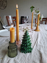 Load image into Gallery viewer, Beckah Evergreen Tree beeswax candle beside golden tapers and a green glass candle holder on a linen-covered table.