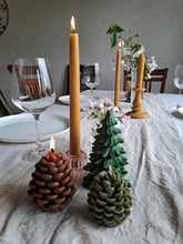 Load image into Gallery viewer, Evergreen Tree and pinecone beeswax candles arranged with golden tapers and white blossom.